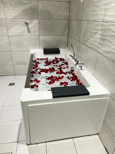 a white bath tub filled with red roses at الذهبية راحتي - golden comfort in Al Thybiyah