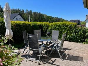 a patio with a table and chairs and an umbrella at Haus am NSG Baaber Heide in Baabe