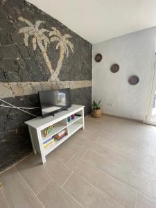 ein Wohnzimmer mit einem TV und einem weißen Schrank in der Unterkunft Apartamento Joshualba in Mesquer