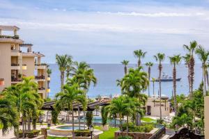 a view of a resort with palm trees and the ocean at Villa La Estancia - Medano Beach Villas in Cabo San Lucas