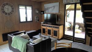 a living room with a couch and a television at CHALET BORD DE MER in Lingreville