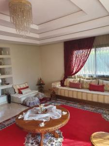 Marrakech le joyau Big villa piscine privée jardin في مراكش: غرفة معيشة مع أريكة وطاولة