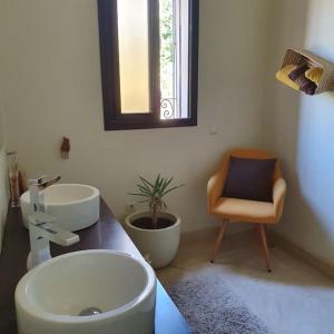 a bathroom with a sink and a mirror and a chair at Marrakech le joyau Big villa piscine privée jardin in Marrakesh