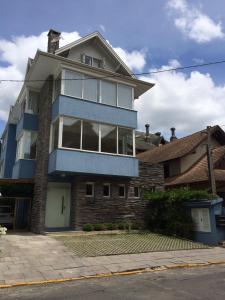 uma casa grande com um azul em Solar do Centro em Gramado