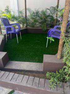 dos sillas moradas sentadas en un parche de hierba en Exquisite 5 Bedroom Villa in Kano en Kano