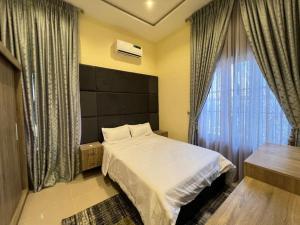 a bedroom with a large bed and a window at Exquisite 5 Bedroom Villa in Kano in Kano
