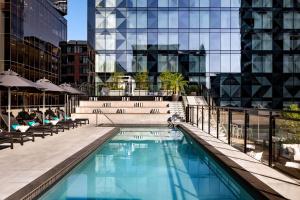 a swimming pool with chairs and a building at Humaniti Hotel Montreal, Autograph Collection in Montréal