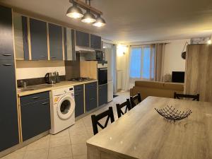 a kitchen and living room with a table and a washing machine at bas de Villa "Le Tiste" in Valensole