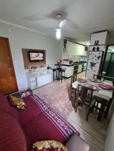 sala de estar con sofá rojo y cocina en APARTAMENTO BC, en Balneário Camboriú
