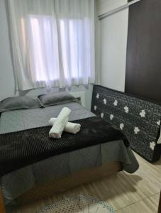 Un dormitorio con una cama con una toalla blanca. en APARTAMENTO BC, en Balneário Camboriú