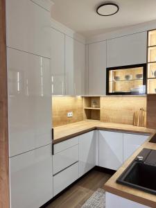 a white kitchen with white cabinets and a sink at Luxury Apartment Kadic in Sarajevo