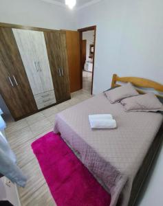 1 dormitorio con 1 cama grande con alfombra rosa en APARTAMENTO BC, en Balneário Camboriú