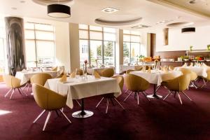 コウォブジェクにあるApartament Spa&Wellnesの白いテーブルと黄色い椅子が備わるレストラン