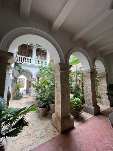 an empty courtyard with arches and potted plants at Loft en Casa Colonial del Centro Histórico de Cartagena in Cartagena de Indias