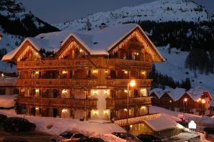 ein großes Gebäude im Schnee bei Nacht in der Unterkunft Chalet Barbara in Arabba + 82 Fotos