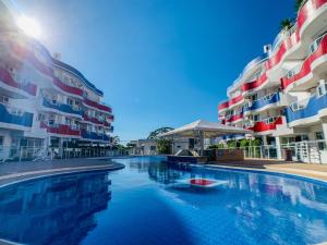 una piscina frente a dos edificios de apartamentos en Maravilhoso apto com vista para o mar e piscina - HB03F, en Florianópolis