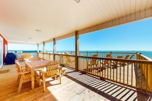 a balcony with a table and chairs and the ocean at SunKissed in Dauphin Island
