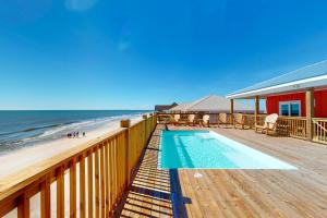 a swimming pool on a deck next to the beach at SunKissed in Dauphin Island