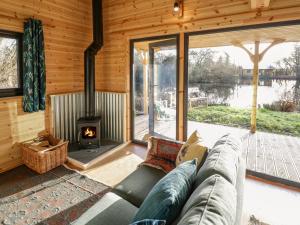 a living room with a couch and a fireplace at Kingfisher in Rugby