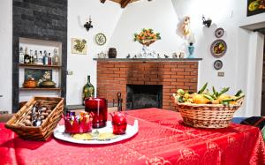 a table with a red table cloth and a fireplace at Casa Leopina Apri gli occhi e vola oltre il mare in SantʼAlfio