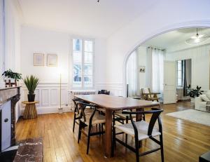 een woonkamer met een houten tafel en stoelen bij GoldSwan, Chic et Confortable au Coeur de Troyes ! in Troyes