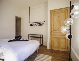 - une chambre avec un lit blanc et une porte en bois dans l'établissement GoldSwan, Chic et Confortable au Coeur de Troyes !, à Troyes