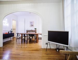 een eetkamer met een tafel en een flatscreen-tv bij GoldSwan, Chic et Confortable au Coeur de Troyes ! in Troyes