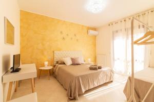 een slaapkamer met een bed, een bureau en een televisie bij CJ SEA HOME CAMERE in Trapani