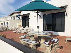 - une table de pique-nique avec un parasol sur la terrasse dans l'établissement Casa Safari frente a la playa, à Ensenada