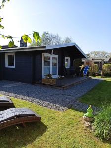 a blue house with a patio and a yard at Ferienhaus kleines Ostseeglück in Brodersby