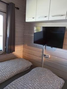 a bedroom with a bed and a flat screen tv at Ferienhaus kleines Ostseeglück in Brodersby OT Schönhagen +13 photos