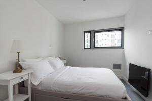 Habitación blanca con cama y ventana en Cardiff City Centre Apartment, en Cardiff