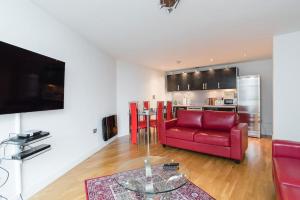 sala de estar con sofá rojo y mesa en Cardiff City Centre Apartment, en Cardiff