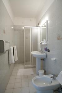 a white bathroom with a sink and a shower at Hotel Ristorante Klaus in Porto Tolle