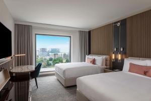 シャーロットにあるJW Marriott Charlotteのベッド2台と大きな窓が備わるホテルルームです。