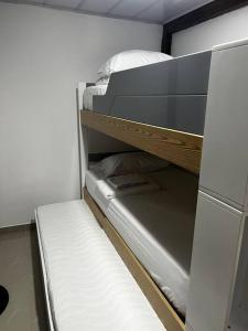 - un réfrigérateur vide dans une chambre avec des lits superposés dans l'établissement Cabaña confortable y familiar, à Coveñas