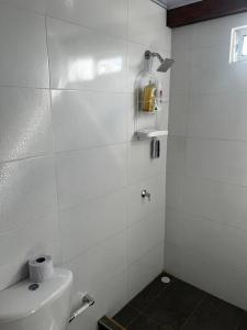 uma casa de banho branca com um WC e uma janela em Cabaña confortable y familiar em Coveñas