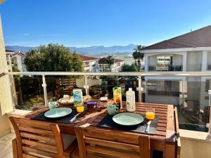 a wooden table with plates of food on a balcony at Lovely 2-Bed Apartment in Side - Ilica in Side