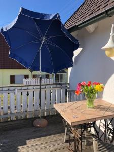 a table with a blue umbrella on a deck at Superschöne Ferienwohnungen! in Buxheim