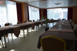 una fila de mesas en una habitación con ventanas en Quars Garden Hotel, en Koçyazı