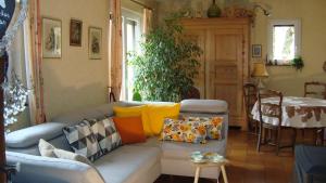 un soggiorno con divano, cuscini e tavolo di Les Corneilles 