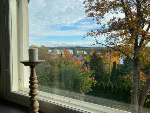 a candle in front of a window with a view at Idyllic sea view house in Porvoo