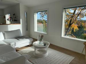 a living room with a couch and a table and two windows at Idyllic sea view house in Porvoo