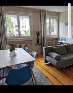 uma sala de estar com um sofá e uma mesa em Velay cocon appartement 4 chambres avec vue sur les monuments em Le Puy-en-Velay