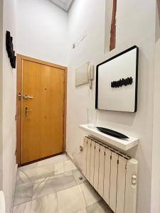 a room with a door and a television on the wall at Las Letras Acogedor Huertas San Pedro in Madrid