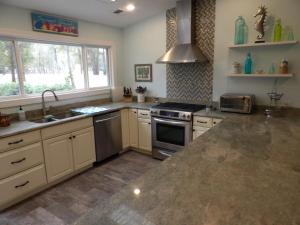 a kitchen with a sink and a stove top oven at Bike & Beach Bungalow at Oyster Bay-Sunset Beach in Sunset Beach