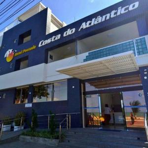 un edificio azul con un cartel en la parte delantera en Hotel Costa do Atlântico, en João Pessoa