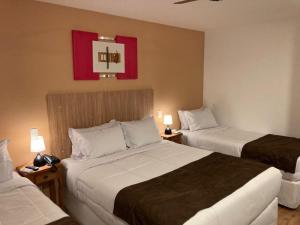 サン・ペードロ・ダ・セーハにあるPousada Renovo da Serraのホテルルーム ベッド2台&ランプ2つ付