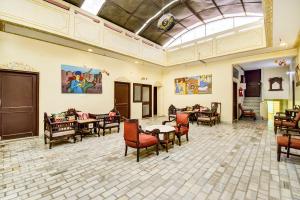 una sala da pranzo con tavoli, sedie e soffitto di Noble House - A Heritage Home a Jaipur