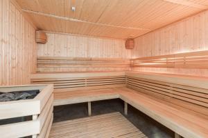 a sauna with wooden benches and a wooden ceiling at Dziwnow Luxurious Apartment No1 by the River by Renters Prestige in Dziwnów